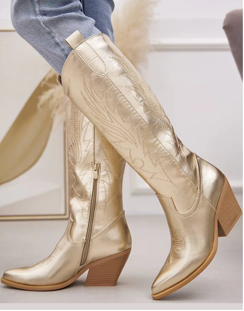 Women's metallic gold knee-high Western cowboy boots with pointed toe and block heel.